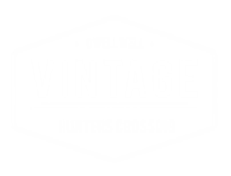 A black and white logo for Dwell Well Vintage Hunters Crossing.